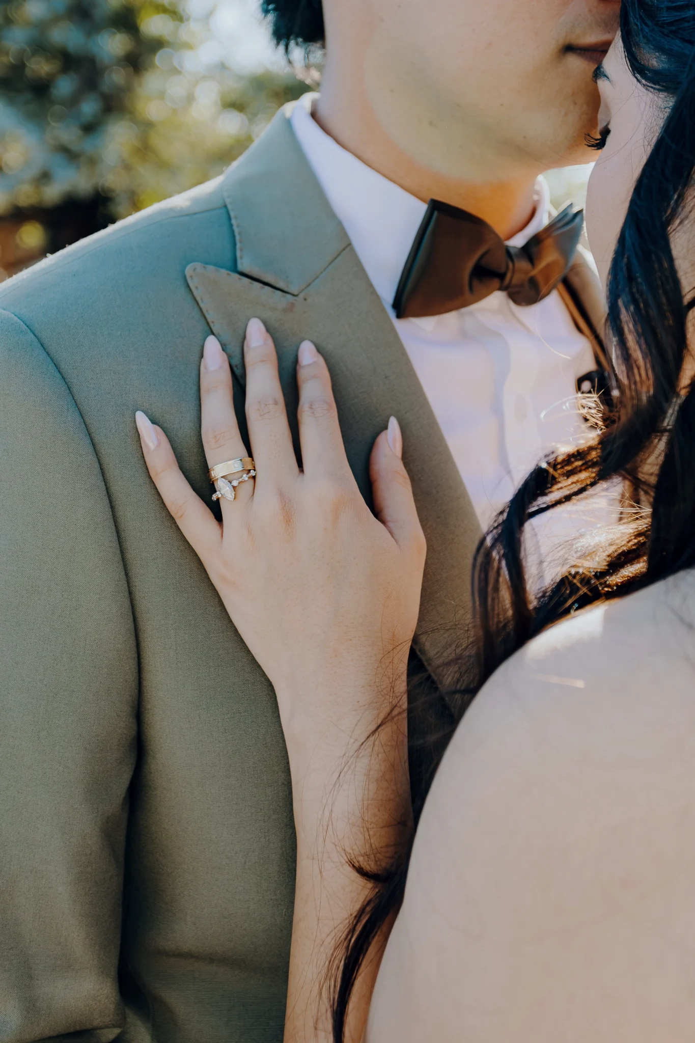 Detalle de la novia apoyando la mano sobre el traje del novio